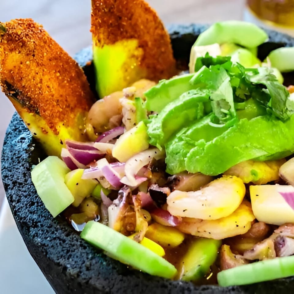 Ruben's Mariscos and Mexican Grill's ceviche with shrimp, avocado, red onion, and cucumber in a dark bowl.