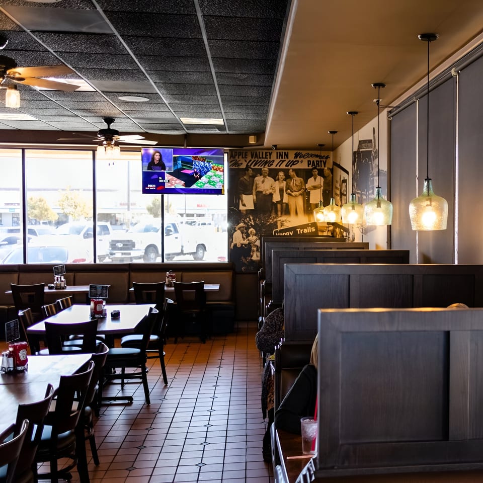 Interior of Ruben's Mariscos and Mexican Grill, showing dining tables, booths, and a large window.
