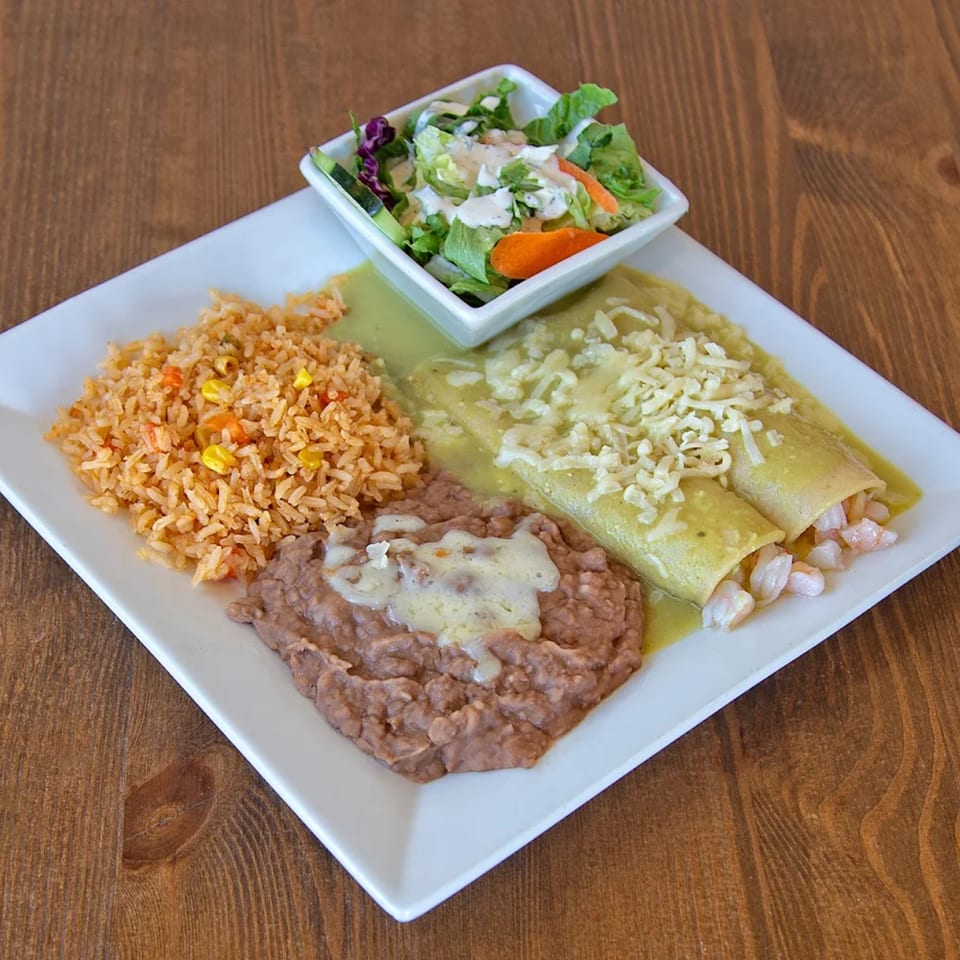 Ruben's Mariscos and Mexican Grill's shrimp enchiladas with green sauce, rice, refried beans, and a side salad.
